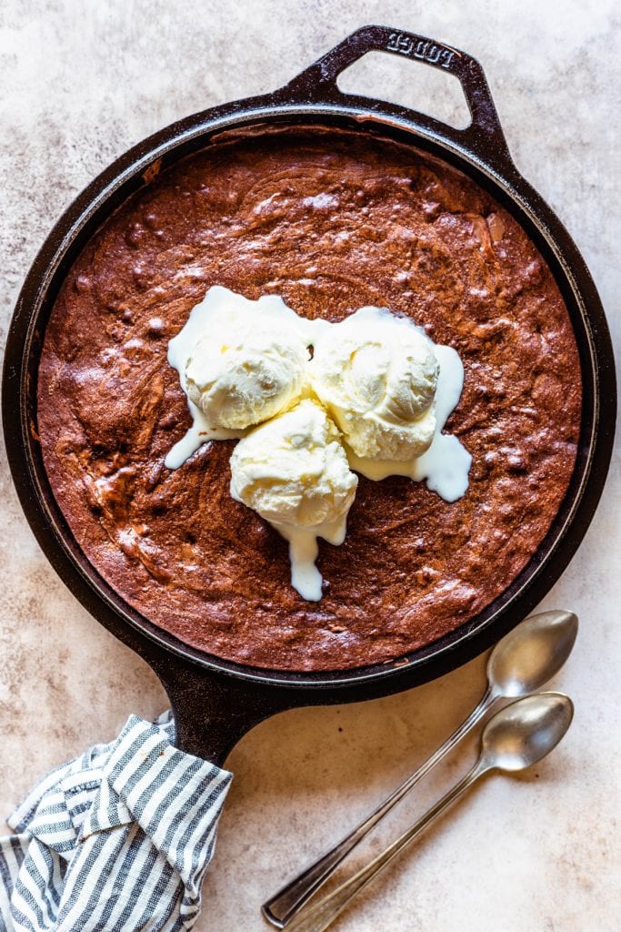 brownies baked on a skillet, topped with ice cream