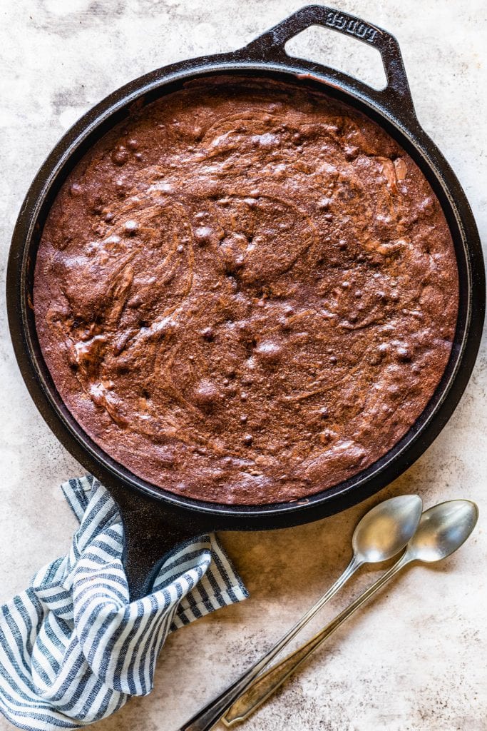 brownies baked on a skillet, with spoons on the side