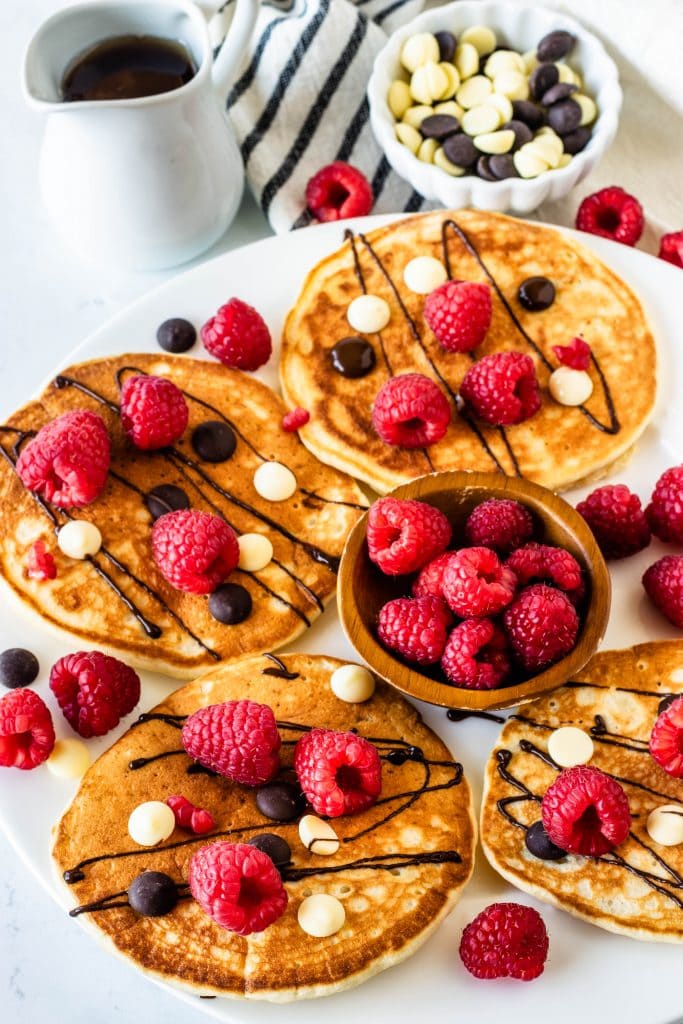 Sourdough Pancakes topped with chocolate drizzle and raspberries
