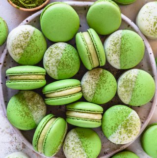 Matcha Macarons dipped in white chocolate topped with matcha powder.