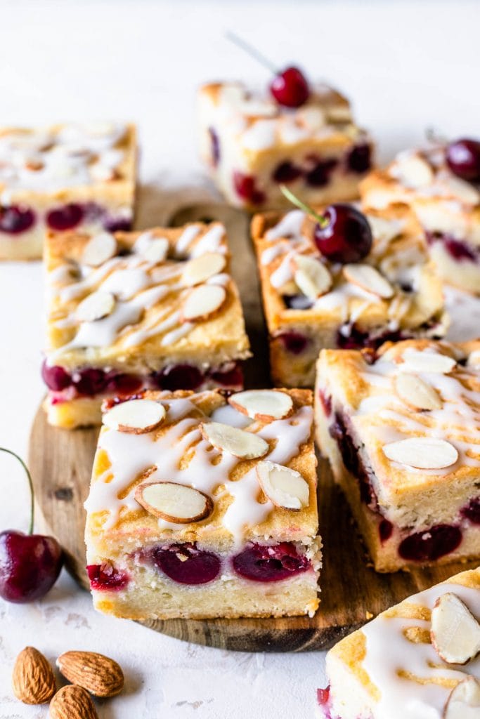 almond cherry bars topped with glaze and sliced almonds