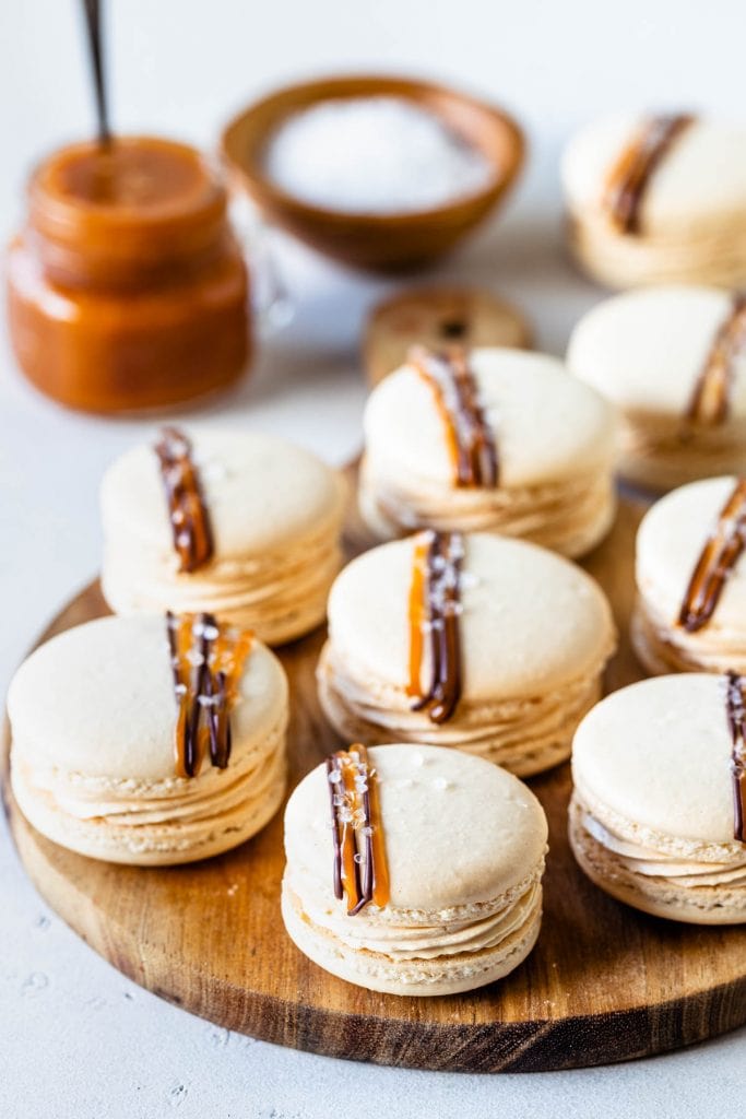 Salted Caramel Macarons filled with buttercream and topped with a drizzle of salted caramel and chocolate