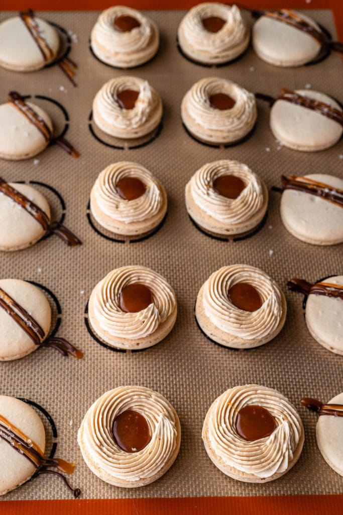 Salted Caramel Macarons shells filled with salted caramel buttercream and salted caramel sauce