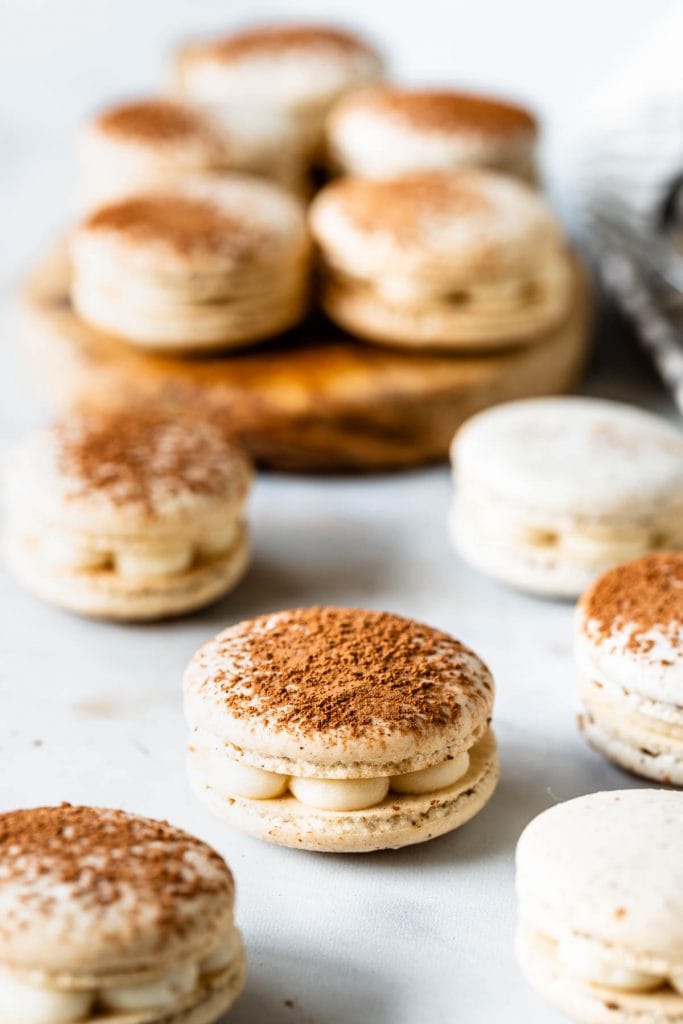 Tiramisu macarons filled with mascarpone frosting, dusted with cocoa powder