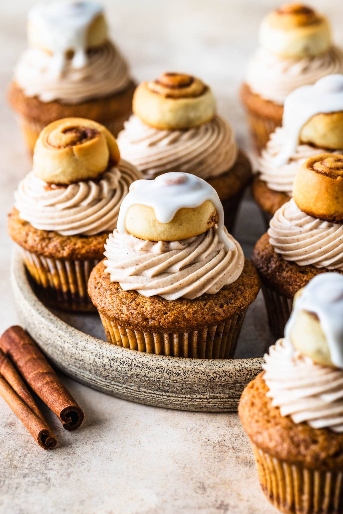Cinnamon Roll Cupcakes topped with cinnamon rolls, some with frosting on top, and some without.