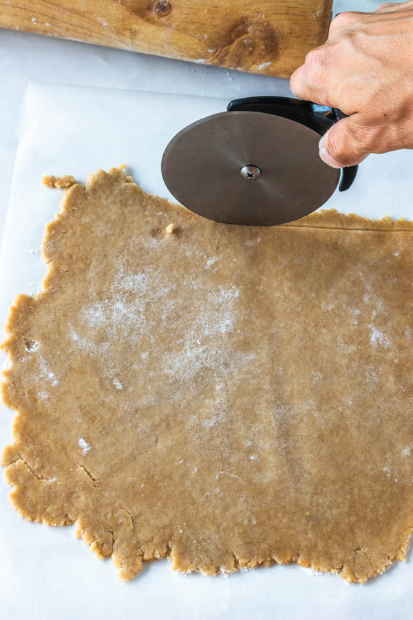 using pizza cutter to trim edges of dough