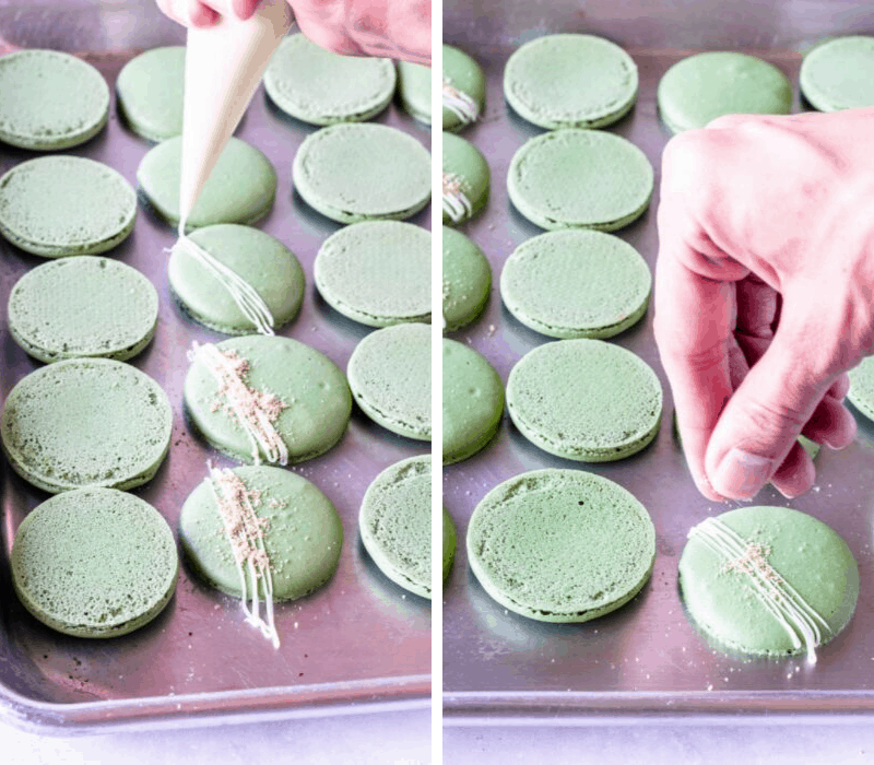 drizzling white chocolate on top of macarons and topping with graham cracker crumbs