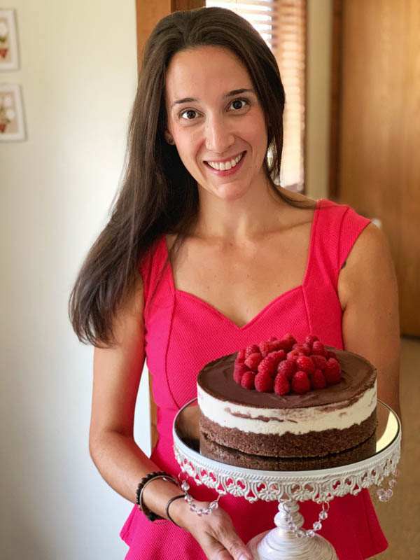woman holding a vegan raspberry cheesecake