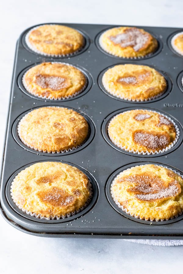cupcakes in cupcake tin baked with cinnamon sugar topping