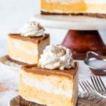 Vegan Pumpkin Cheesecake slice topped with coconut whipped cream