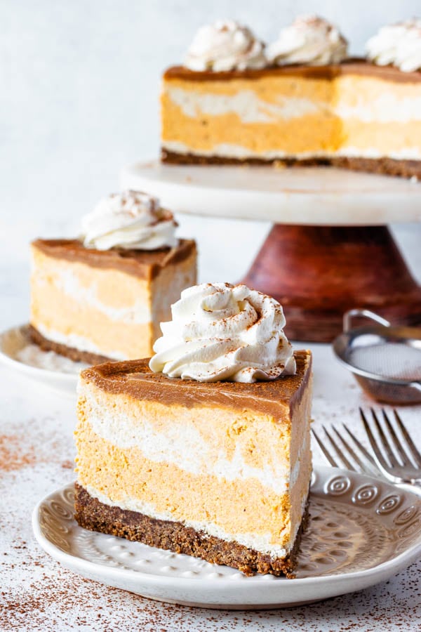 Vegan Pumpkin Cheesecake slice topped with coconut whipped cream