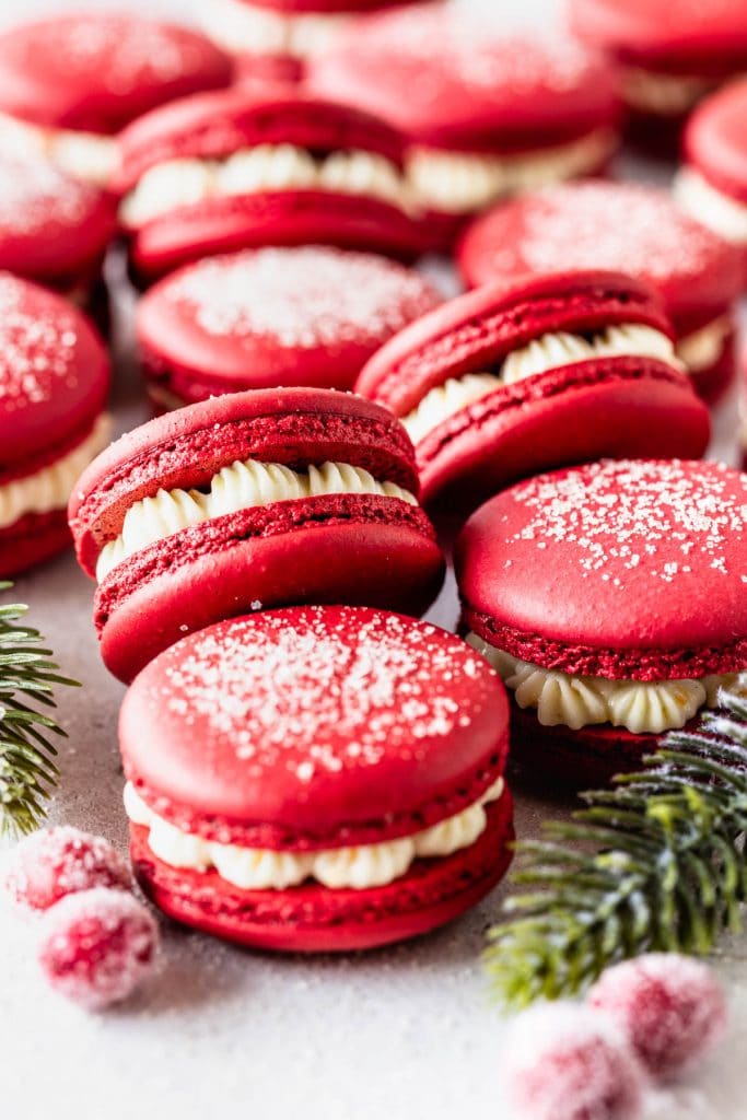 red macarons stacked, filled with cranberry sauce and orange buttercream.