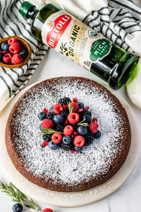 flourless Olive Oil Chocolate Cake dusted with powdered sugar and topped with fresh berries