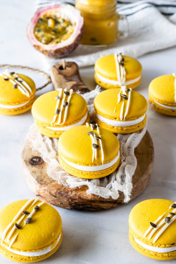 Passion Fruit Macarons filled with passion fruit curd and marshmallow frosting topped with white chocolate and passion fruit seeds
