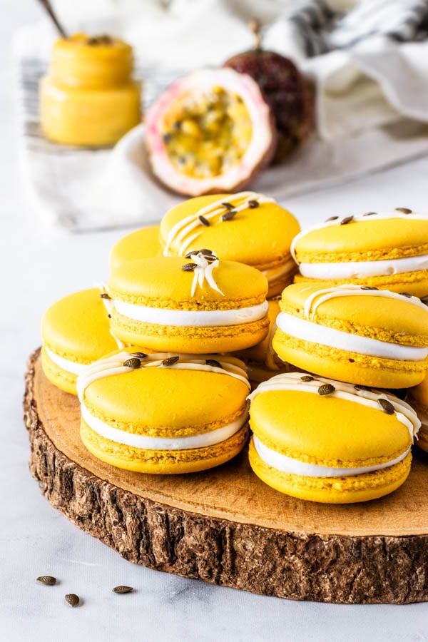 Passion Fruit Macarons filled with passion fruit curd and marshmallow frosting topped with white chocolate and passion fruit seeds