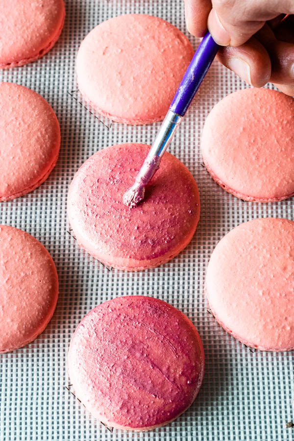brushing champagne macaron shells with rose dust luster