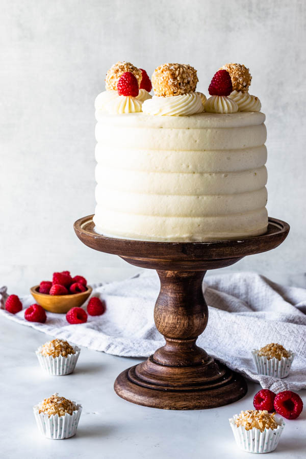 Raspberry Coconut Cake topped with raspberries and coconut fudge truffles