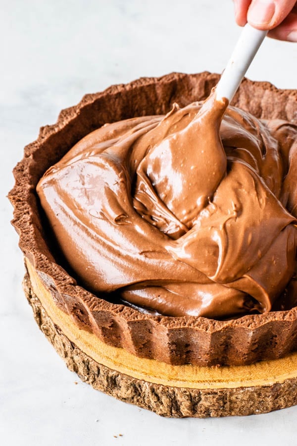spreading the chocolate cheesecake batter in the pie crust