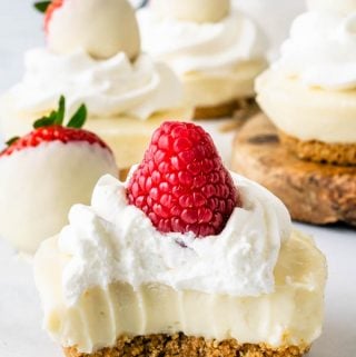 No-Bake White Chocolate Cheesecake bite topped with whipped cream and raspberries