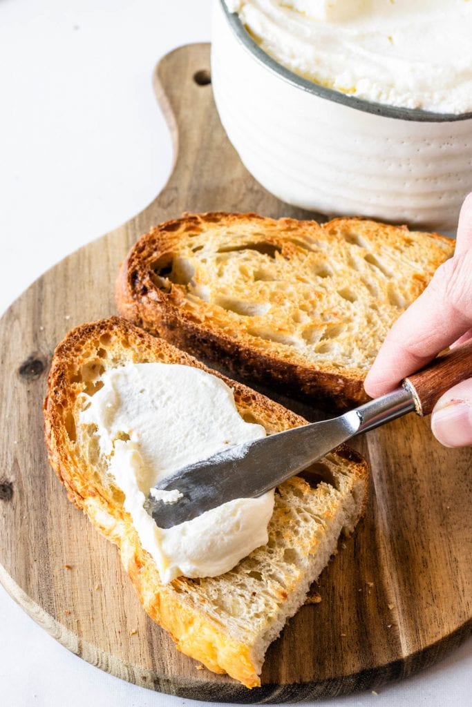 spreading homemade ricotta on toast