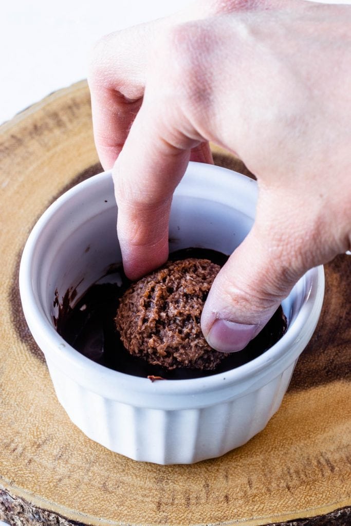 dipping chocolate coconut macaroons in melted chocolate