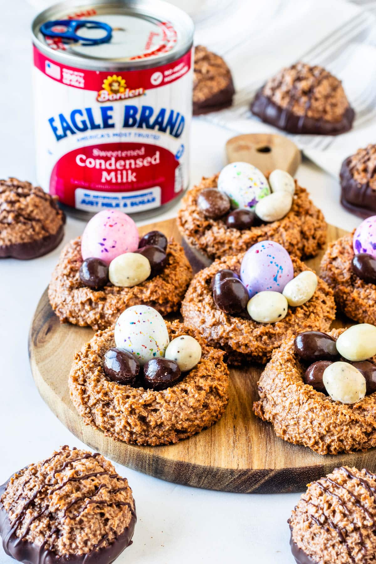 Chocolate coconut macaroon Easter nests filled with colorful chocolate eggs, served alongside traditional dipped macaroons.