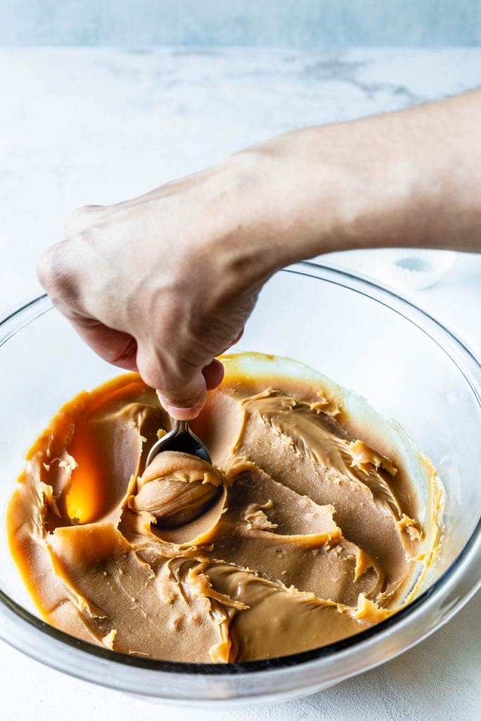 scooping caramel fudge with a spoon
