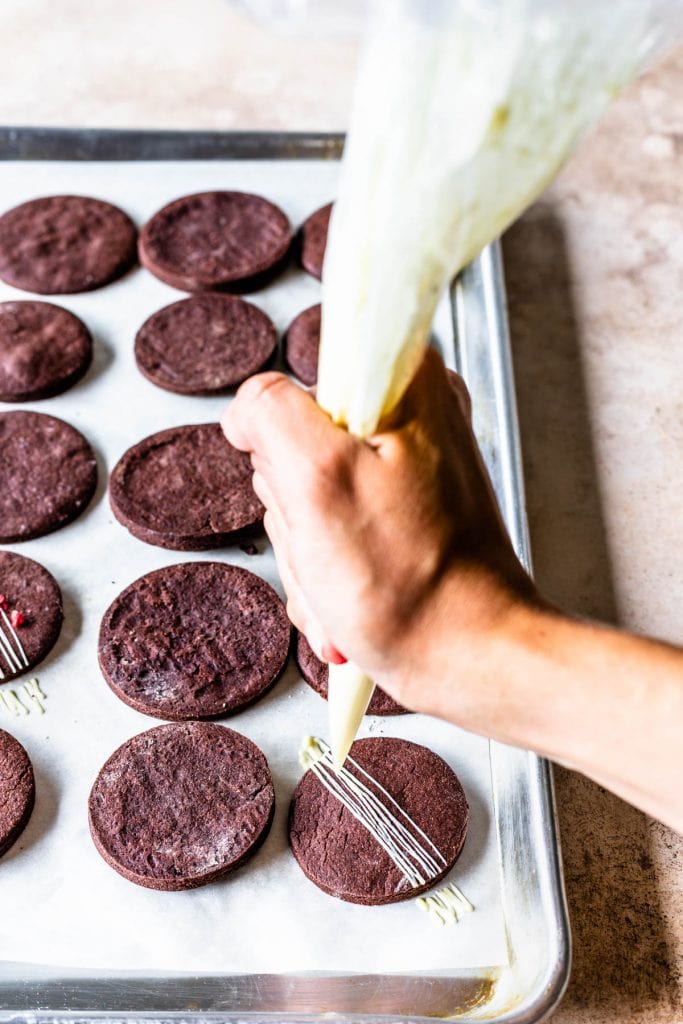 drizzling chocolate cookies with melted white chocolate
