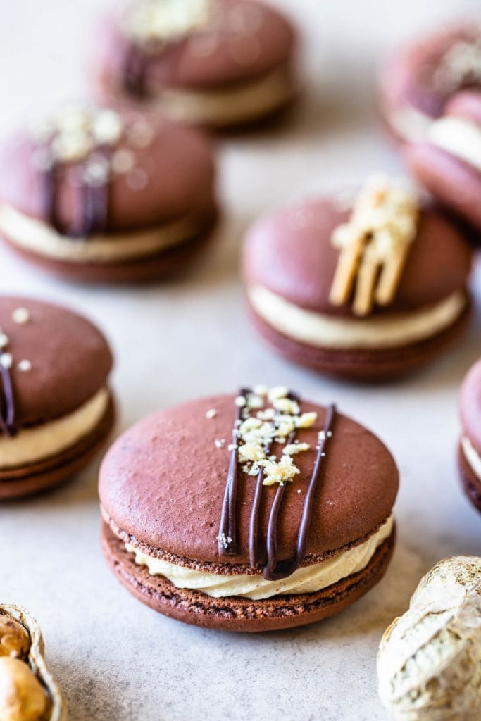 Peanut Butter Macarons topped with peanut butter drizzle and chopped peanuts