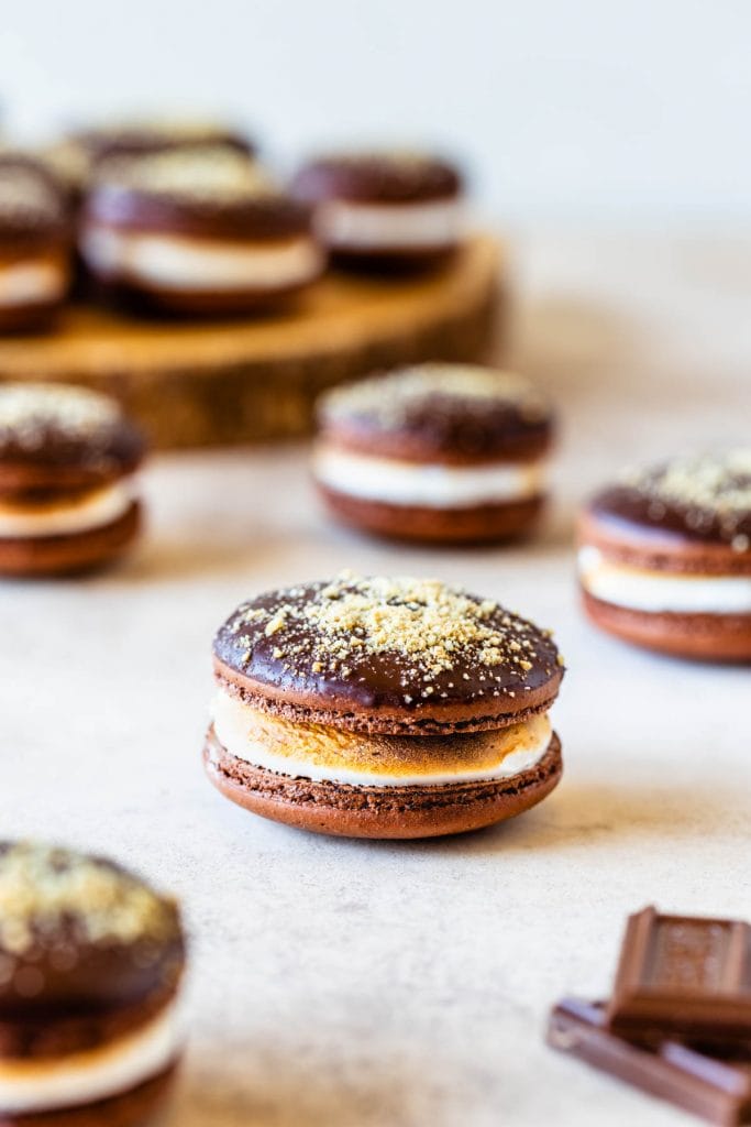 S'mores Macarons dipped in chocolate topped with graham cracker crumbs filled with toasted marshmallow
