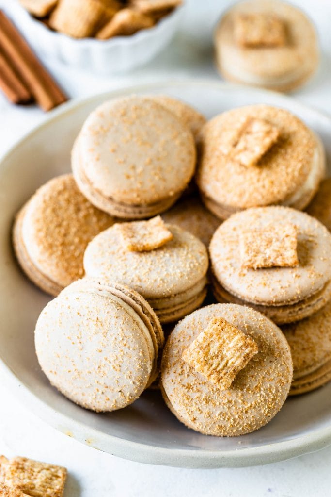 Cereal macarons dusted with cinnamon toast crunch cereal powder, filled with cinnamon toast crunch buttercream