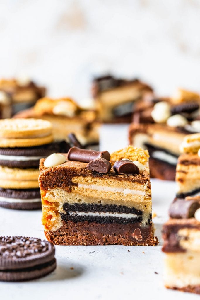 oreo bars layered with brownies, oreos and blondies, stacked on top of each other