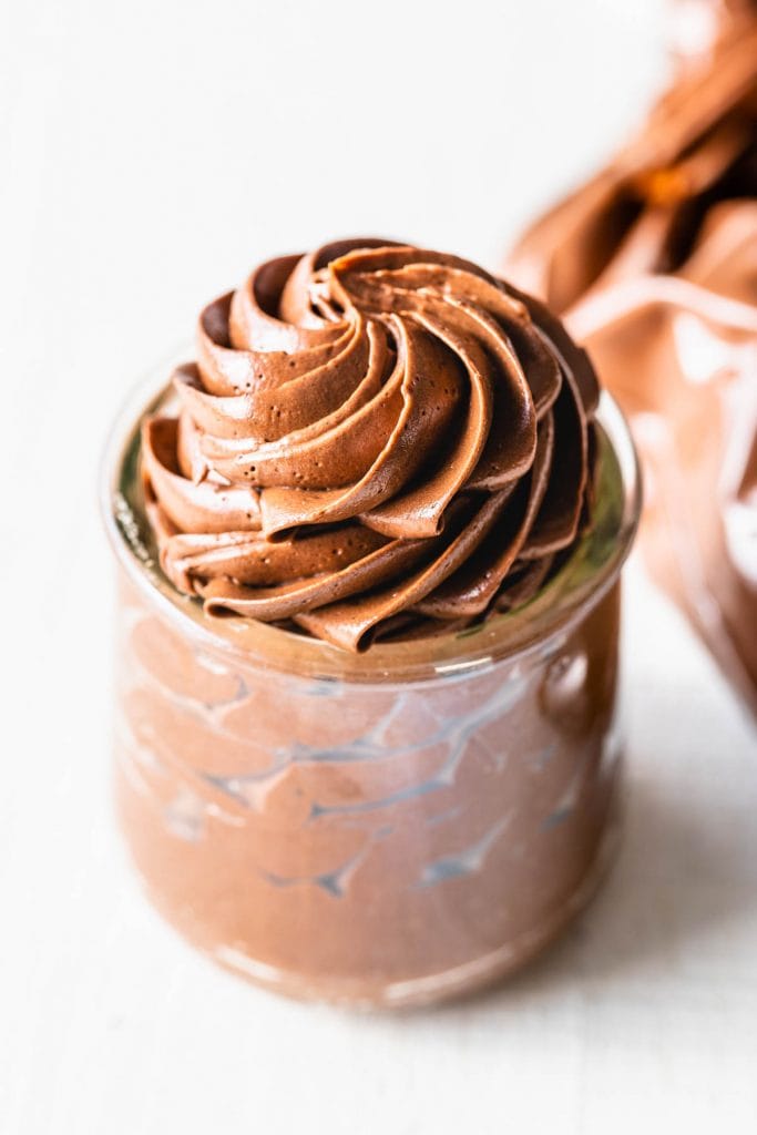 condensed milk chocolate frosting piped in a glass jar.