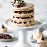 Coffee Macaron Cake, macaron shells filled with mocha and espresso frosting, topped with frosting, chocolate covered espresso beans.