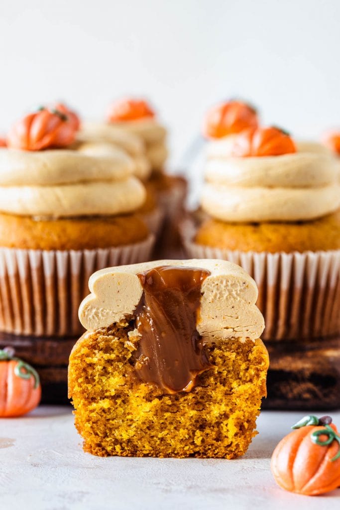 pumpkin cupcakes filled with dulce de leche cut in half showing the filling.