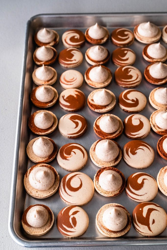 macaron shells filled with cinnamon cream cheese frosting.