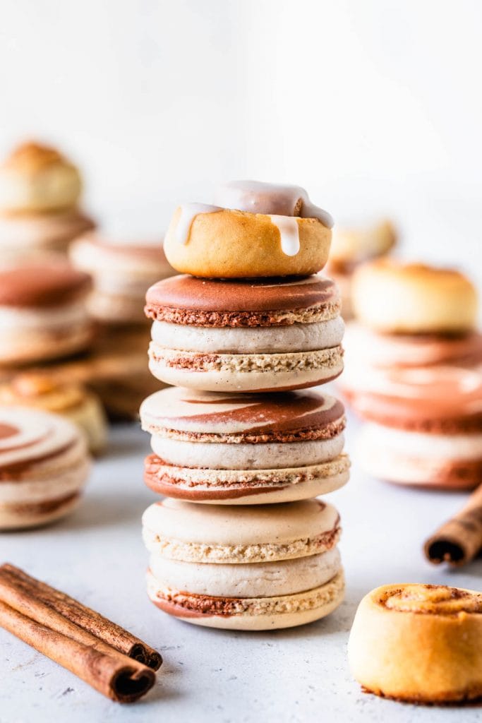 stacked cinnamon macarons topped with a cinnamon roll.
