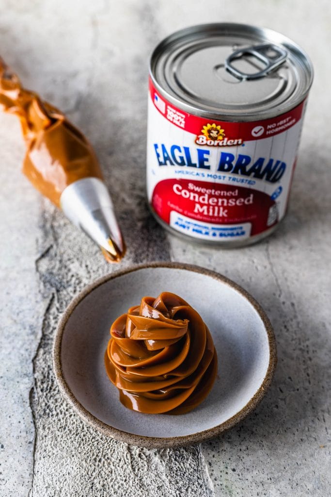 dulce de leche piped on a small dish with a can of condensed milk on the side.