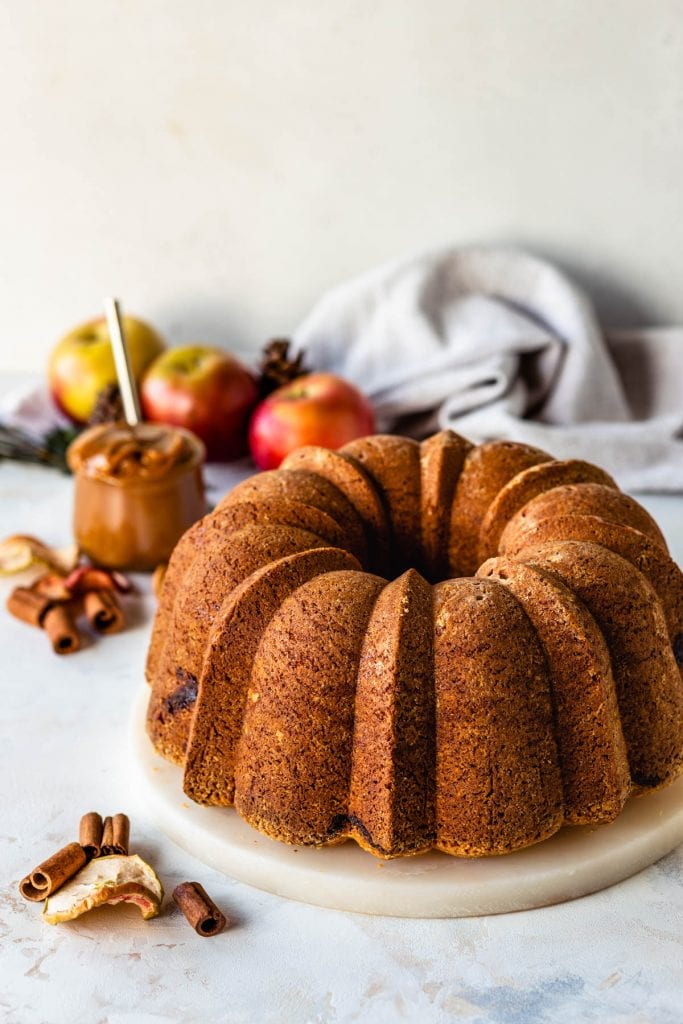 apple bundt cake, with apples on the background.