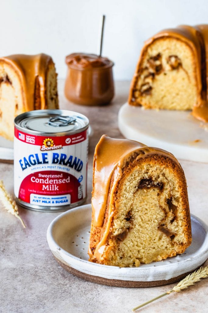 slice of apple cake with a caramel drizzle, and a can of condensed milk in the back.