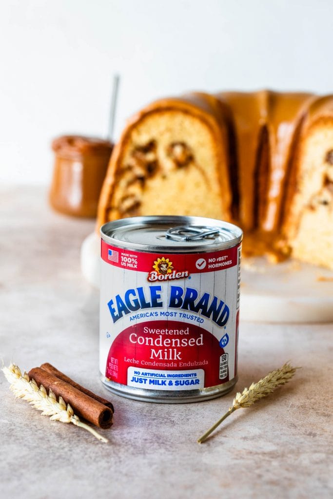 can of eagle brand® sweetened condensed milk in front of a cake.