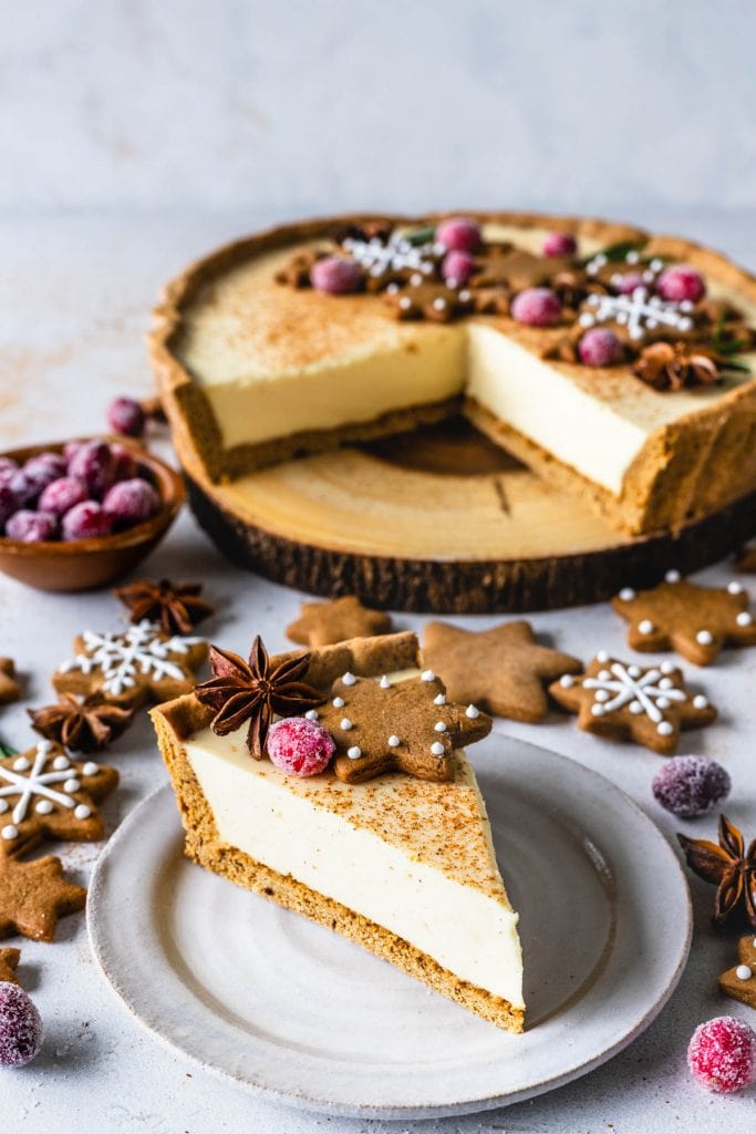 slice of christmas pie filled with eggnog topped with gingerbread cookies and sugared cranberries.