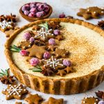 Eggnog Pie topped with gingerbread cookies, rosemary sprigs and sugared cranberries.