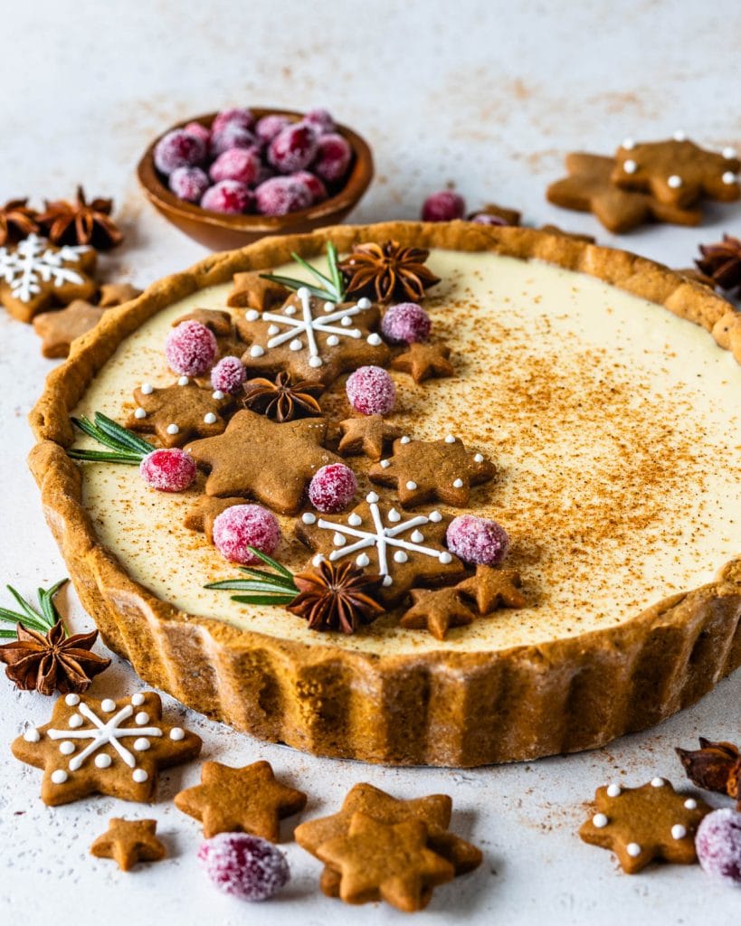 Eggnog Pie topped with gingerbread cookies, rosemary sprigs and sugared cranberries.