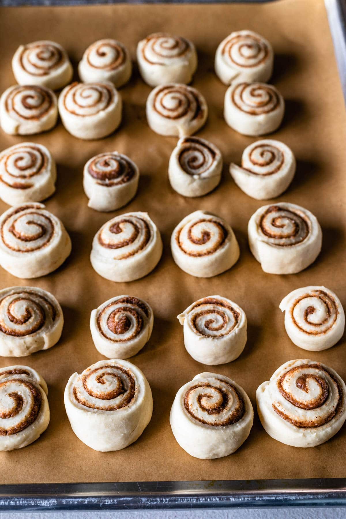 tray with unbaked cinnamon rolls on top.