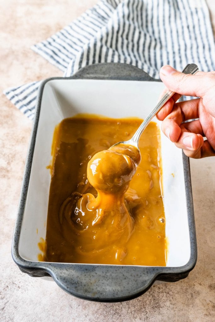 dulce de leche baked in the oven and a spoon scooping some dulce de leche.
