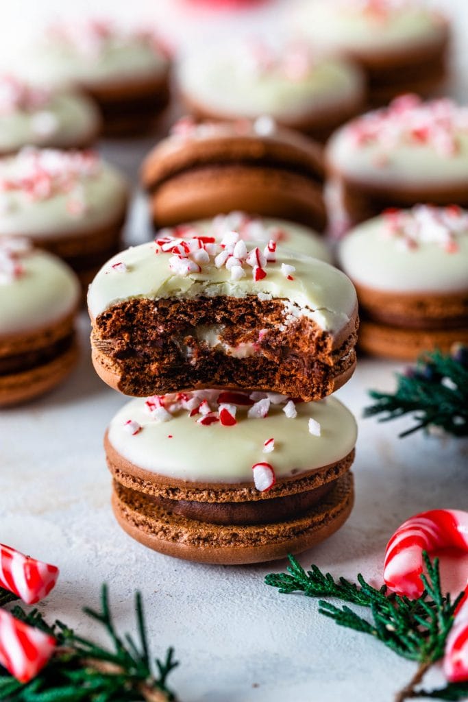 Peppermint Bark Macarons stacked and with a bite taken out.