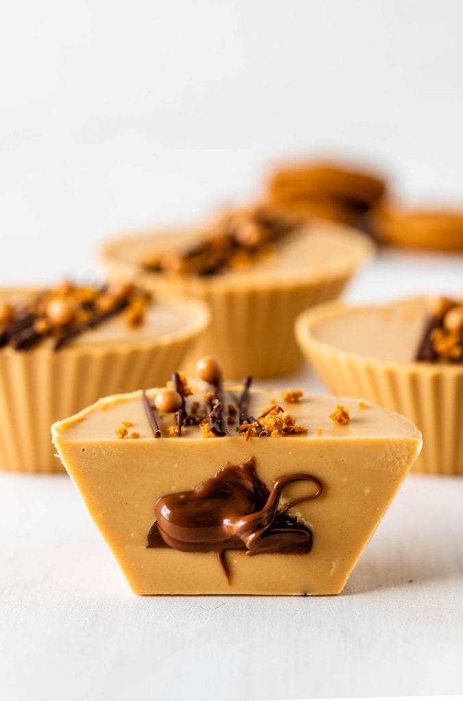 biscoff cups filled with nutella decorated with melted chocolate, callebaut crispearls and biscoff crumbles on top.