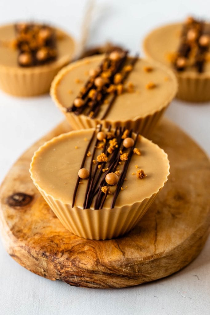 biscoff cups filled with nutella decorated with melted chocolate, callebaut crispearls and biscoff crumbles on top.