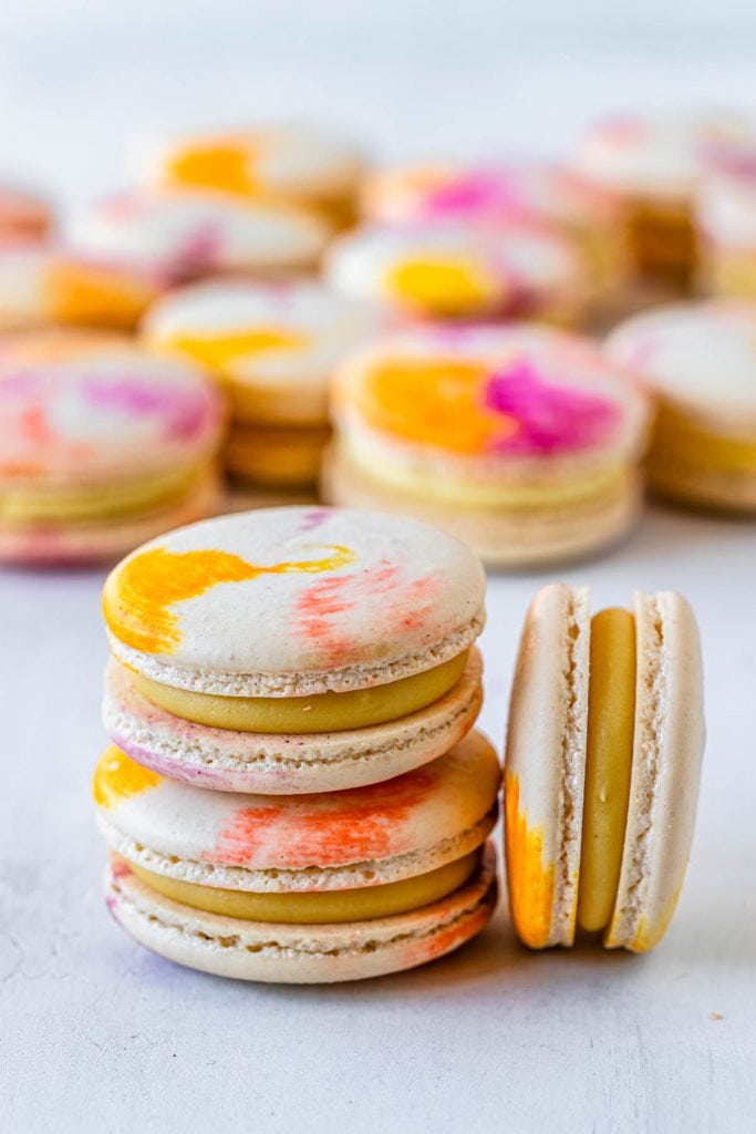 passionfruit macarons with a tie dye macaron shell filled with passionfruit ganache.
